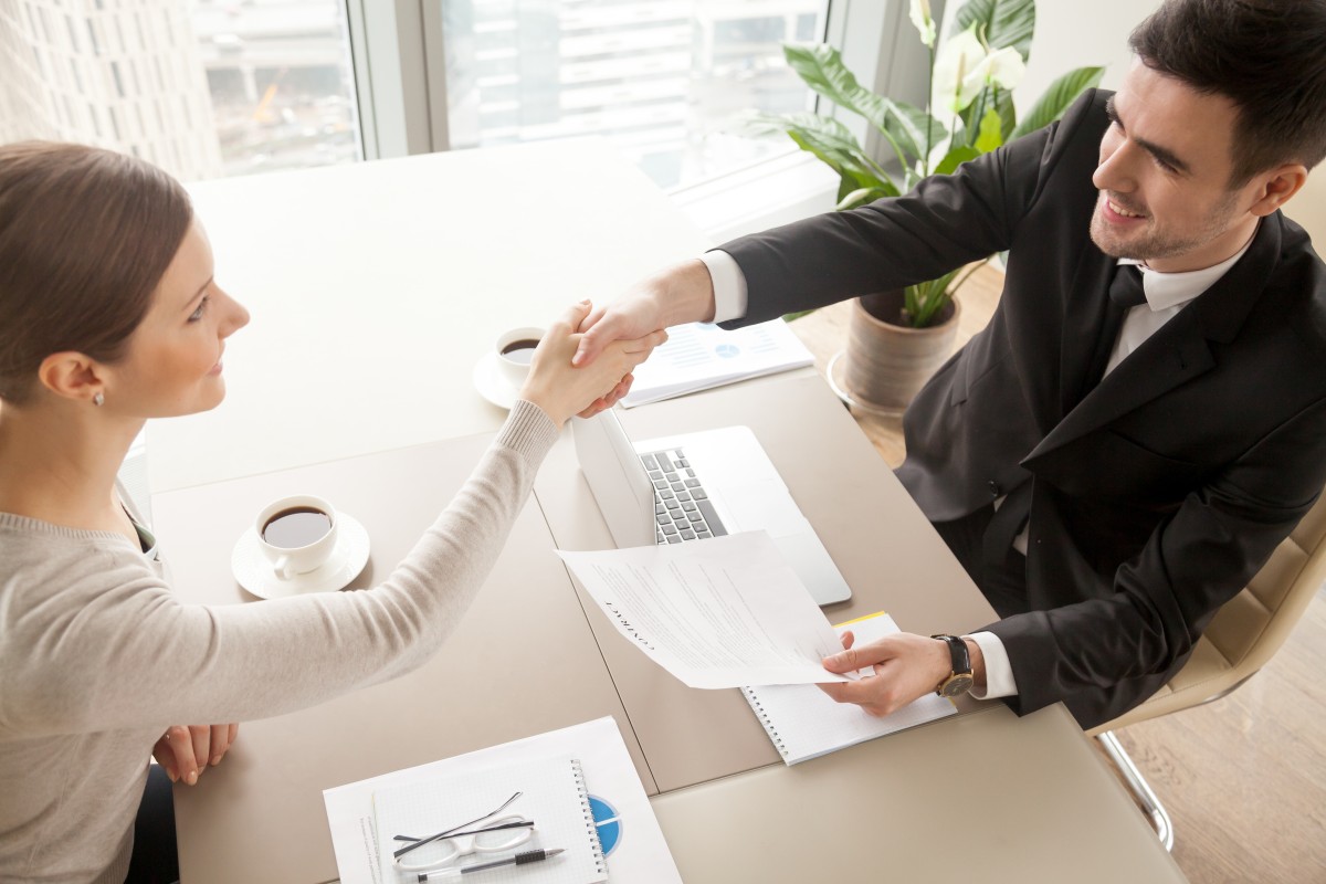 Un hombre y una mujer celebran un contrato