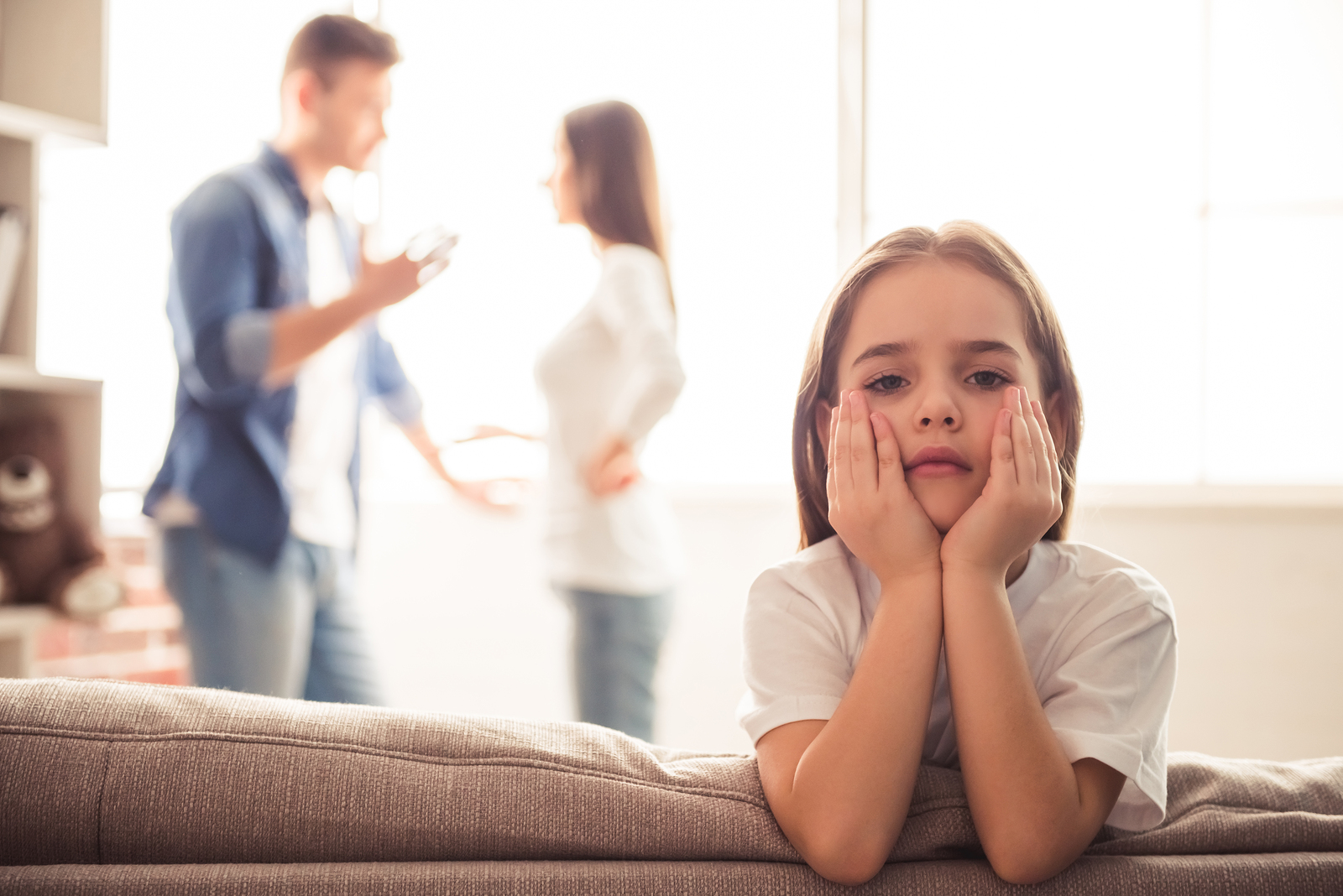 Niña triste mientras sus padres discuten