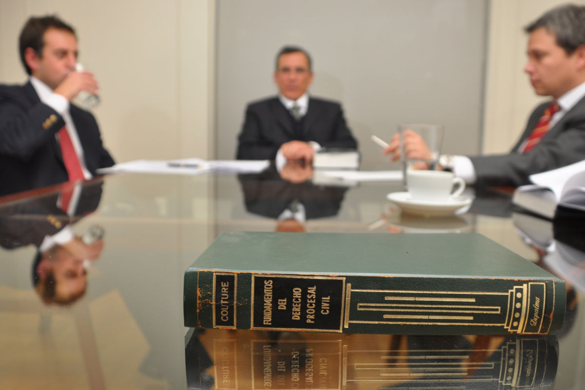 Tres hombres reunidos en una mesa